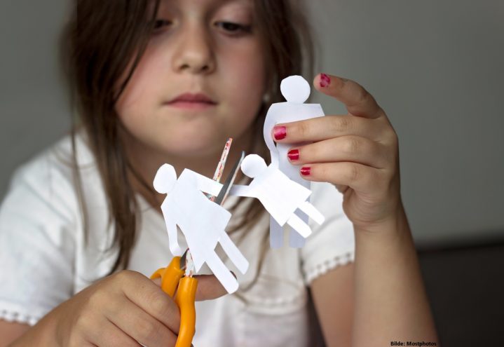 Illustrasjonsfoto: Barn som klipper i stykker en papirlenke som illustrerer en familie.