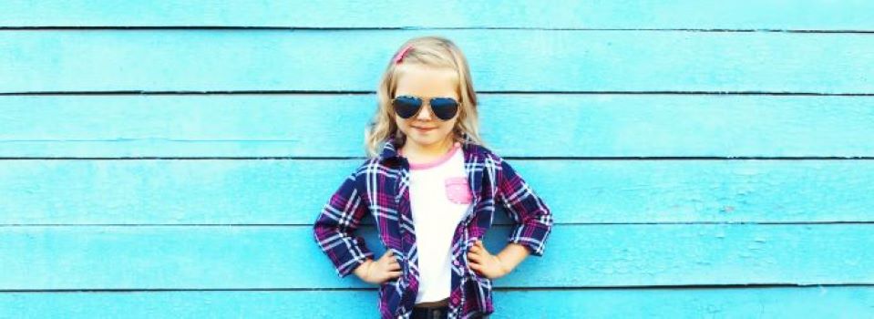 A girl wearing sunglasses with her hands on her hips