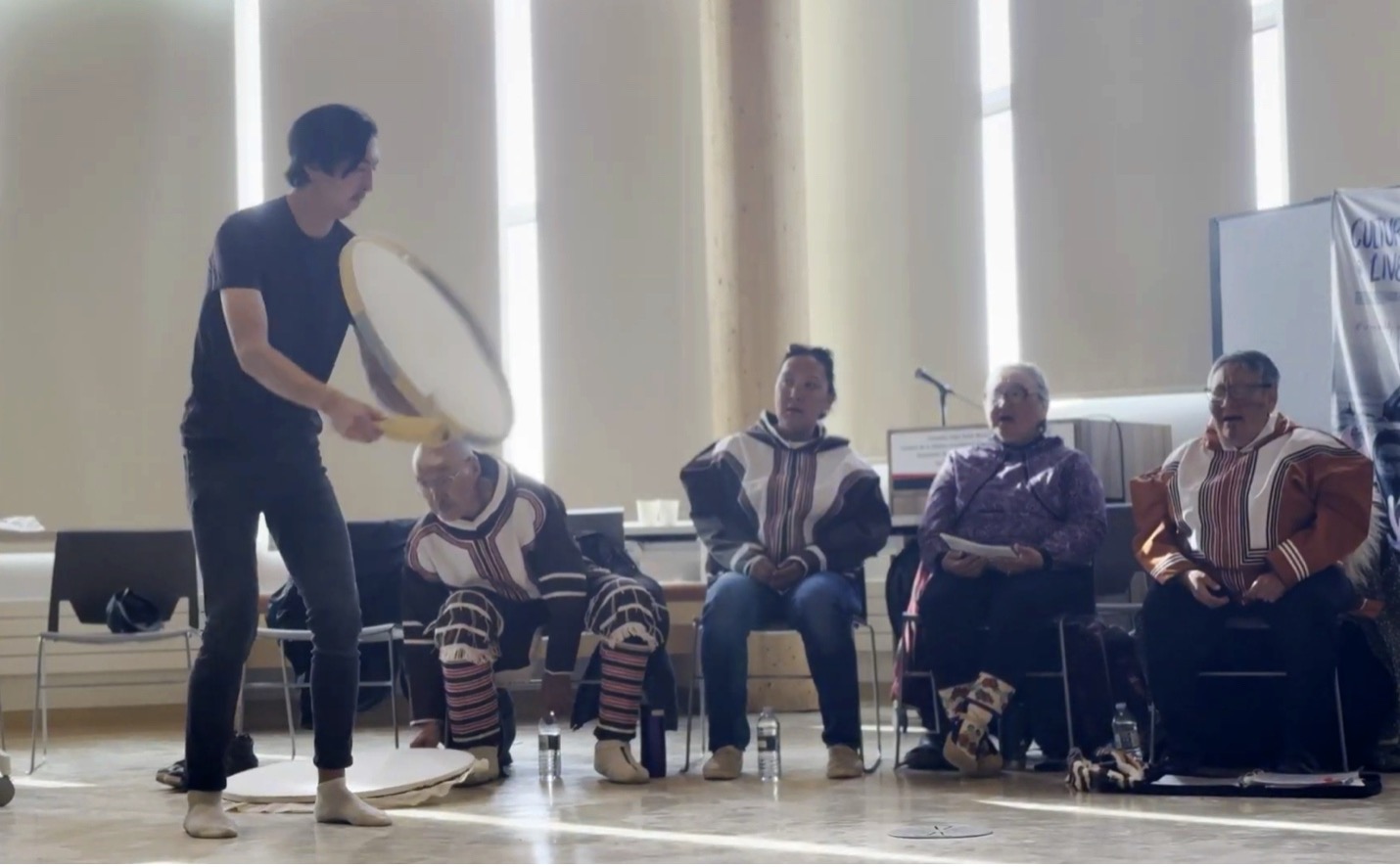 People playing a drum and listening